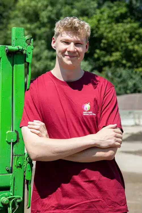 Junge Dame mit roten Haaren und geflochtenem Zopf in Arbeitskleidung