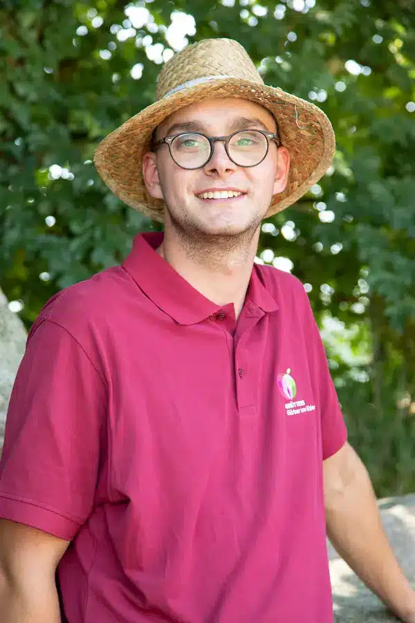 Junger Mann mit Brille und kurzem, blondem Haar, lächelt in die Kamera.